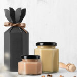 Jars of honey in various colors with a black gift box and wooden honey dipper, representing hobbies related to food and lifestyle.